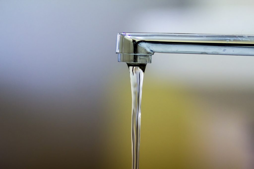 Close-up of faucet with turned drop water in modern bathroom. Ho