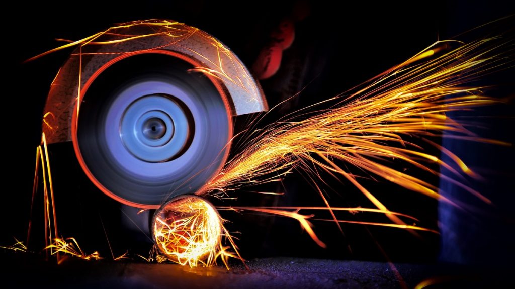 Worker cutting metal with grinder