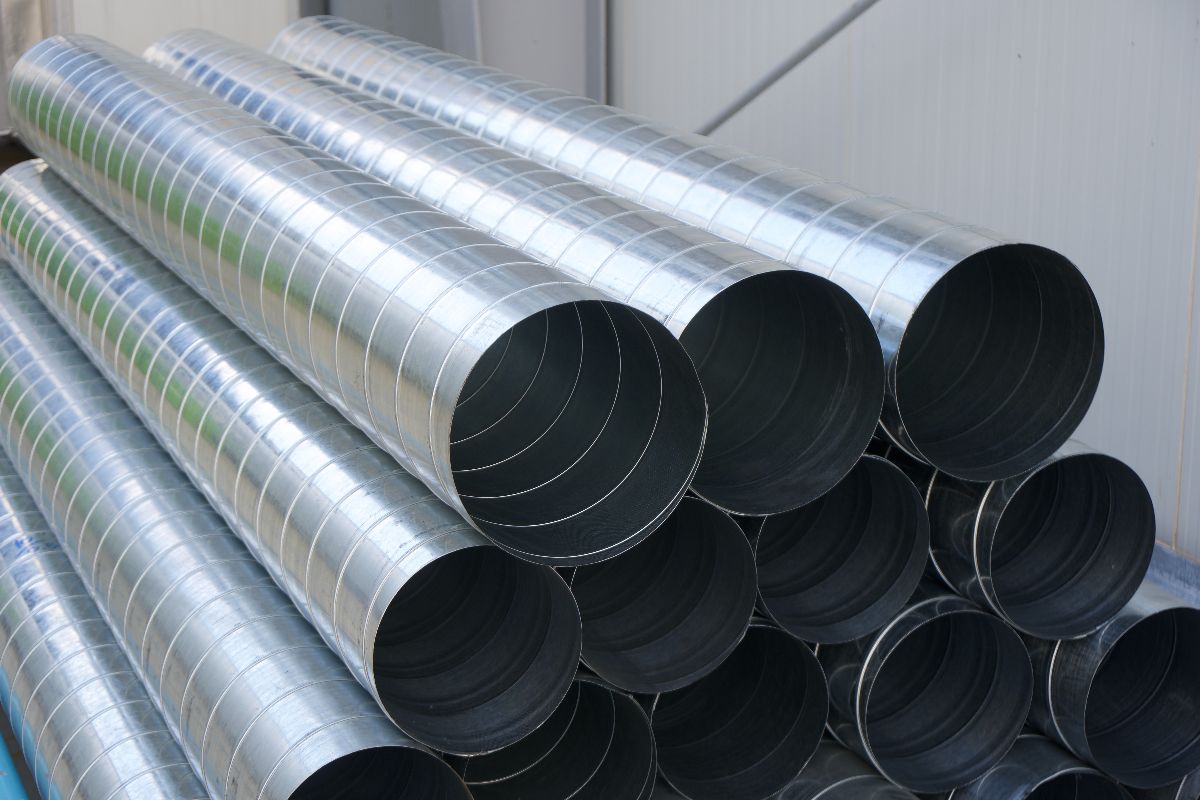 Spiral metal pipes stacked together, showing large round openings and galvanized surfaces