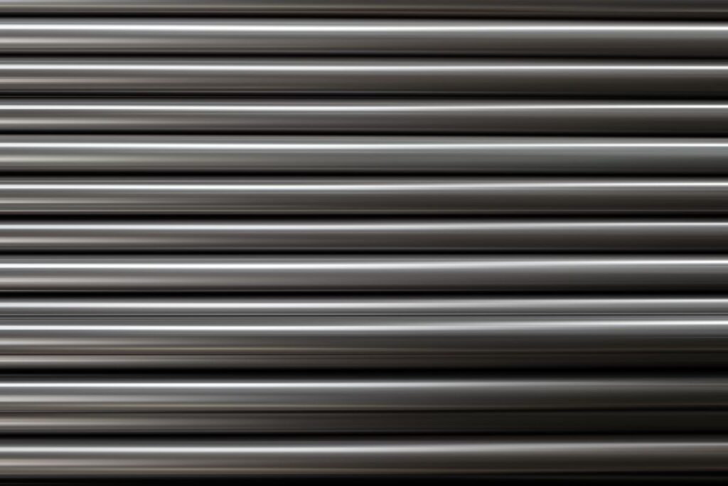 Smooth galvanized iron pipes arranged horizontally, highlighting their uniform finish and structural form